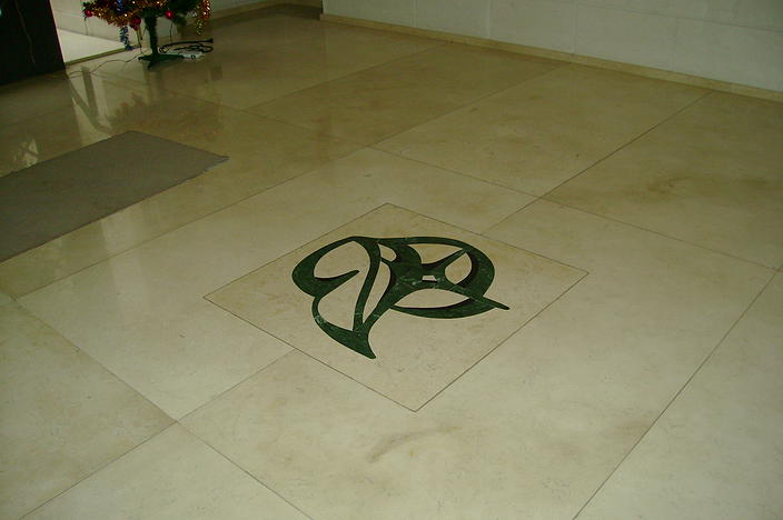 Piso de mármol con guarda decorativa en mármol verde